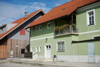 a green house with a red roof at Hostel Mladinski center Šmartno ob Paki in Šmartno ob Paki