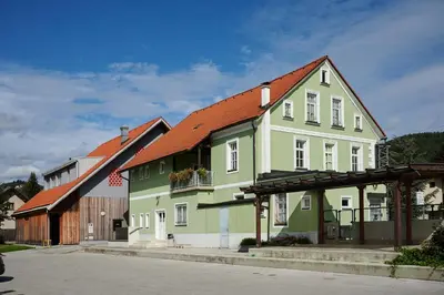 a green and white house with an orange roof at Hostel Mladinski center Šmartno ob Paki in Šmartno ob Paki