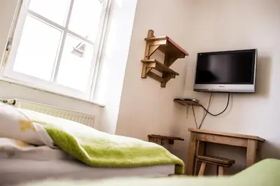 a bedroom with a tv on the wall and a bed at Hostel Mladinski center Šmartno ob Paki in Šmartno ob Paki