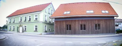 a large wooden building with a red roof on a street at Hostel Mladinski center Šmartno ob Paki in Šmartno ob Paki