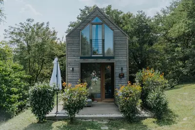 a tiny house with a glass door and a lawn at GORIČKE IŽE in Križevci