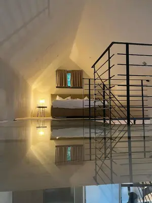 a bedroom with a bed and a spiral staircase at GORIČKE IŽE in Križevci