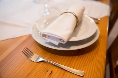 a plate with a napkin and a fork on a table at Holiday Farm Grofija in Ivančna Gorica