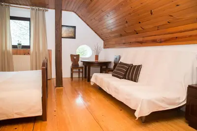 a bedroom with two beds and a table at Holiday Farm Grofija in Ivančna Gorica
