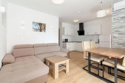 a living room and kitchen with a couch and a table at Vila Vita Apartments in Kranjska Gora