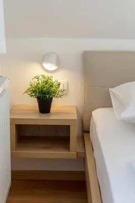 a bedroom with a table with a plant on it at Vila Vita Apartments in Kranjska Gora