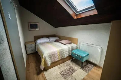 a small bedroom with a bed and a skylight at Koča sredi gozda in Kanal