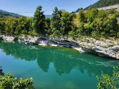 a river with a reflection in the water at Koča sredi gozda in Kanal
