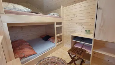 a bedroom with bunk beds in a wooden room at Koča sredi gozda in Kanal