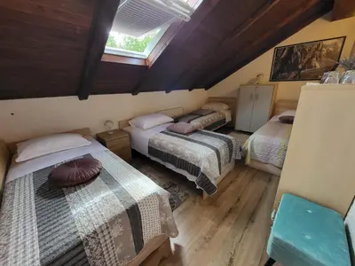 a attic room with two beds and a window at Koča sredi gozda in Kanal