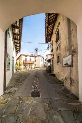 an empty street with an archway between two buildings at Aldilà Art Rooms, Apartment and Vacation House in Šmartno