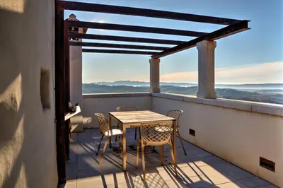 a table and chairs on a balcony with a view at Aldilà Art Rooms, Apartment and Vacation House in Šmartno