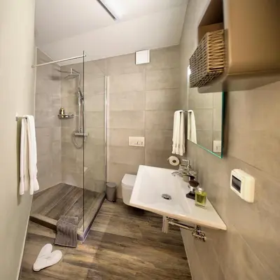 a bathroom with a shower and a sink and a toilet at Aldilà Art Rooms, Apartment and Vacation House in Šmartno