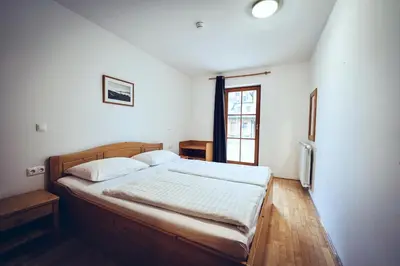 a bedroom with a bed in a room with a window at Pohorje Village Wellbeing Resort - Family Apartments Bolfenk in Pohorje