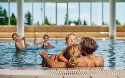 a group of people in a swimming pool at Pohorje Village Wellbeing Resort - Family Apartments Bolfenk in Pohorje