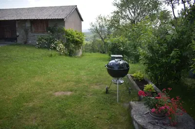 a grill sitting on a stand in a yard at Barbara`s Village House in Ilirska Bistrica