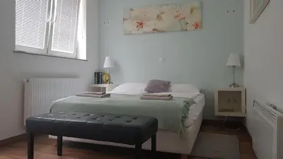 a bedroom with a bed with a ottoman in it at Bled Apartments in Bled