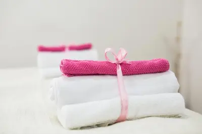 a stack of towels with a pink bow on top at Bled Apartments in Bled