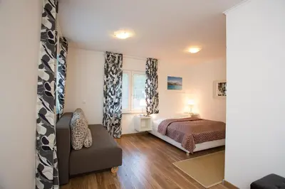 a bedroom with a bed and a couch and a window at Bled Apartments in Bled