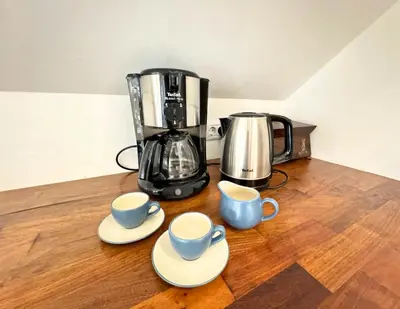 a coffee maker and two cups on a wooden table at Luxury holiday home near Lake Bled & the Alps in Kropa