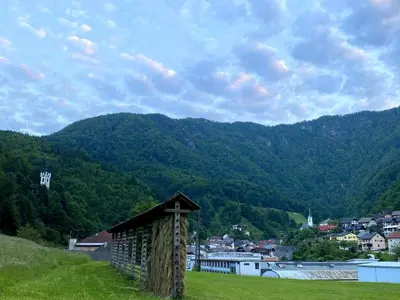 a small building in a field with mountains in the background at Luxury holiday home near Lake Bled & the Alps in Kropa