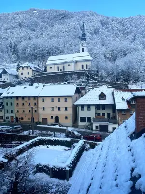 a town with snow covered buildings and a church at Luxury holiday home near Lake Bled & the Alps in Kropa
