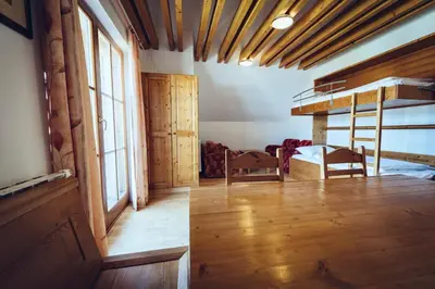 a room with a bunk bed and wooden floors at Pohorje Village Wellbeing Resort - Forest Apartments Videc in Pohorje