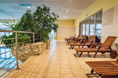 a hallway with benches and plants in a building at Pohorje Village Wellbeing Resort - Forest Apartments Videc in Pohorje