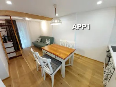 a living room with a table and chairs and a couch at Alpine Village Home in Bohinj