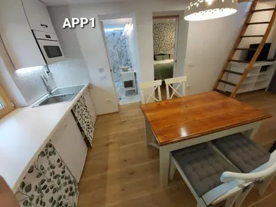 a kitchen and dining room with a table and a sink at Alpine Village Home in Bohinj