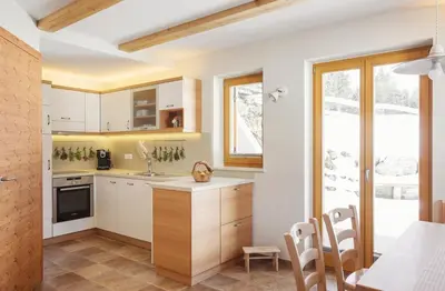a kitchen with white cabinets and a table at Apartment Jezerca - Krvavec in Cerklje na Gorenjskem