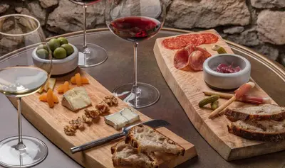 a table topped with two cutting boards with wine glasses at Holiday house VilAna in Puconci