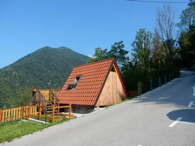 a barn with a red roof on the side of a road at Glamping Tinka in Tolmin