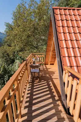 a wooden walkway with a person sitting at a table on it at Glamping Tinka in Tolmin
