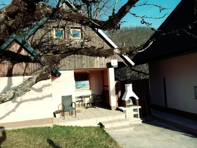 a house with a table and chairs in the yard at apartma HIŠKA KOROŠEC in Bohinj