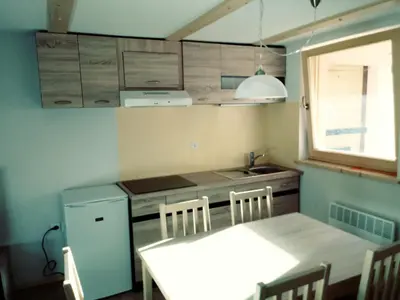 a small kitchen with a table and a sink at apartma HIŠKA KOROŠEC in Bohinj