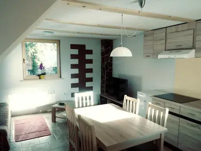 a kitchen with a table and chairs in a room at apartma HIŠKA KOROŠEC in Bohinj