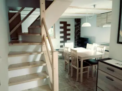 a kitchen and dining room with a staircase and a table at apartma HIŠKA KOROŠEC in Bohinj