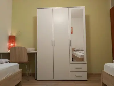 a white cabinet in a bedroom with a desk at apartma MAKS - Kobarid in Podbela