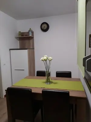 a dining room table with a vase of flowers on it at apartma MAKS - Kobarid in Podbela