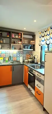 a kitchen with orange and white cabinets and appliances at Boho House 2 camp Terme Catez with promotional tickets prices in Čatež ob Savi