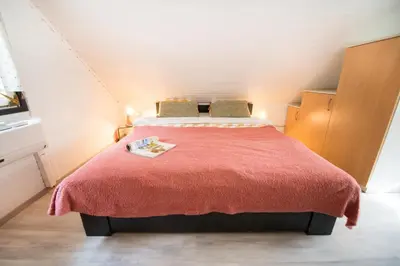 a bedroom with a bed with a red blanket at Boho House 2 camp Terme Catez with promotional tickets prices in Čatež ob Savi