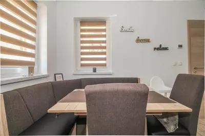 a dining room with a table and chairs and a window at Holiday Home BOR in Podčetrtek