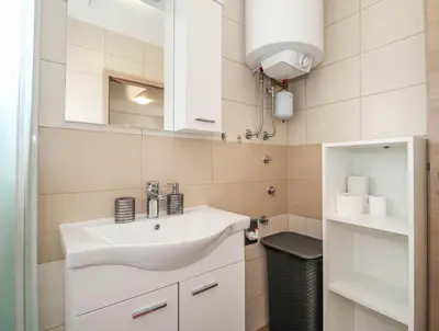 a bathroom with a white sink and a mirror at Holiday Home BOR in Podčetrtek