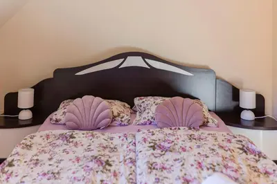 a bed with a purple comforter and pillows at Apartment Pr' Kavač in Rateče