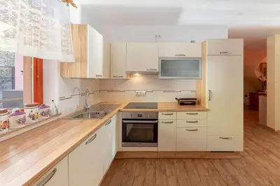 a kitchen with white cabinets and a sink at Apartment Pr' Kavač in Rateče