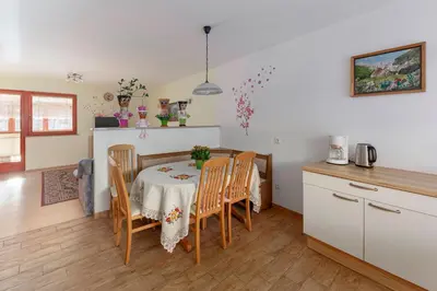 a kitchen and dining room with a table and chairs at Apartment Pr' Kavač in Rateče