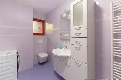 a white bathroom with a sink and a toilet at Apartment Pr' Kavač in Rateče