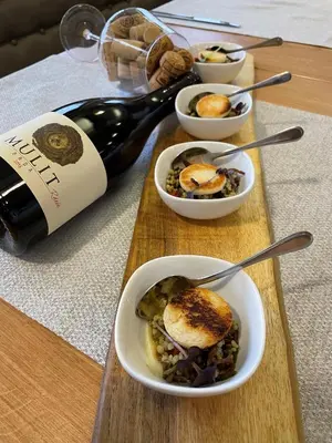 a table with bowls of food and a bottle of wine at Hotel Špica Laško in Laško
