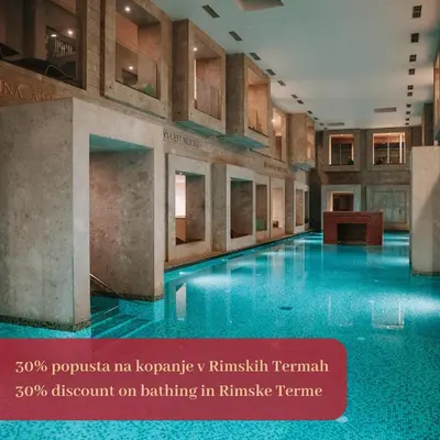 a large swimming pool with blue water in a building at Hotel Špica Laško in Laško